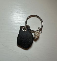 a rock keychain with a skull on it sitting on top of a table