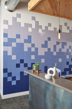 a blue and white tiled wall behind a counter in a room with wood ceilinging