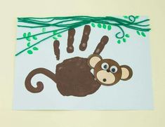 a handprint with a monkey hanging from a tree branch and green leaves on it