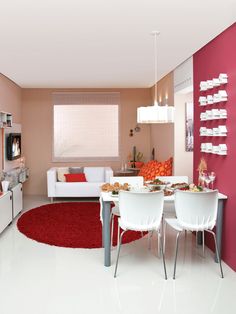 a living room filled with furniture and a red rug on top of a white floor