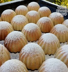 a tray filled with lots of powdered sugar covered pastries