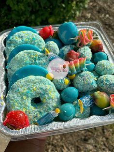 a tray filled with donuts covered in blue frosting and sprinkles