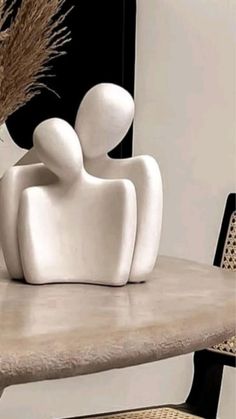 two white sculptures sitting on top of a table