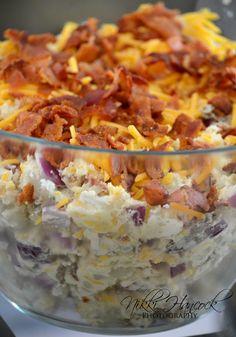 a bowl filled with rice and bacon sitting on top of a table