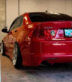 the back end of a red car in a garage