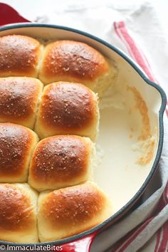 a pan filled with bread rolls on top of a red and white towel