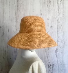 Crochet raffia hat     It is a classic accessory for every woman for sun protection, summer parties, beach and travel. It can be a good gift for a woman of any age. The hat is crocheted of natural raffia, light, elastic, the brim of the hat is reinforced with wire. The hat keeps its shape well and does not fade in the sun. The hat is soft to the touch, slightly rough. It is completely crocheted by hand. Easy to carry thanks to the foldable design. The hat matches perfectly with a summer wardrobe. Color: Straw color Size: 21 1/2 - 23 1/2 inches Field size: about 4 inches Care of the product:        It is better to dry the hat naturally, without using additional heating sources. When the raffia product dries, it returns to its original shape.        You cannot wash them in the usual way. If One Size Wide Brim Crochet Hat For Warm Weather, Woven Short Brim Boater Hat, Beige Brimmed Crochet Hat For Warm Weather, Natural Crochet Hat For Spring, Lightweight Flat Brim Crochet Hat For Spring, Chic Lightweight Natural Straw Hat, Spring Bucket Hat With Uv Protection In Natural Color, Chic Toquilla Straw Hat, Lightweight Summer Crochet Hat With Curved Brim