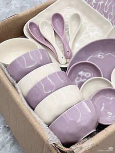 a box filled with purple and white dishes