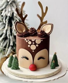 a cake decorated with reindeer's head and trees