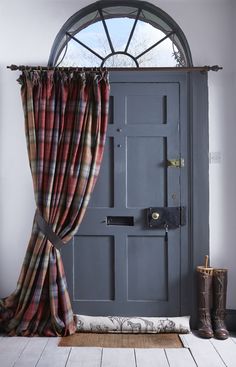 an open door with curtains and boots on the floor