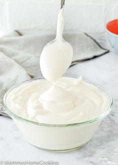 a spoon in a bowl filled with cream