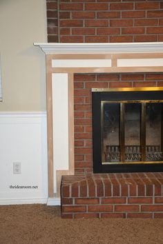 a fire place in the corner of a room with brick and wood trim around it