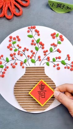 someone is holding up a paper plate with flowers in the center and chinese characters on it