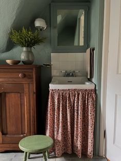 a bathroom with a sink, mirror and stool