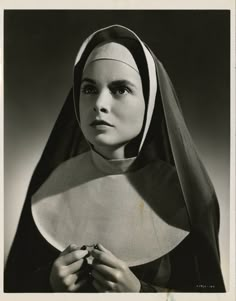 an old black and white photo of a woman wearing a nun's headdress