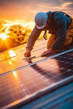 a man working on a solar panel at sunset