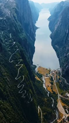 an aerial view of a river surrounded by mountains and roads with writing on the sides