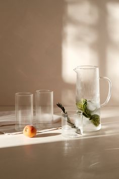 three glasses and an apple on a table