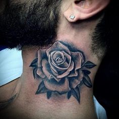 a black and white rose tattoo on the side of a man's neck,