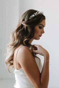 a woman with long hair wearing a white dress and a tiara on her head