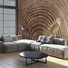 a living room filled with furniture and a large wooden wall behind the couch is a round coffee table