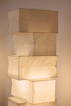 a stack of white boxes sitting on top of a wooden table next to a lamp