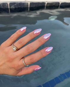 a woman's hand with pink and white manicures holding onto her ring