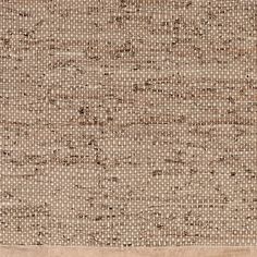 an area rug with brown and white squares on the ground, in front of a beige background