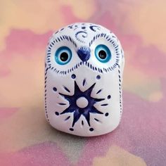 an owl figurine with blue eyes sitting on a table