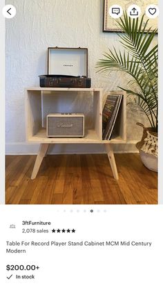 a table with an old radio on it and a palm tree in the corner next to it