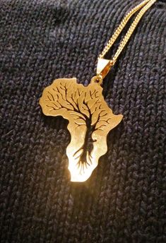 Beautiful and weighty gold tone, shining Africa necklace; the map pendant featuring the continent of Africa measures 4cm.  Etched on both sides of the pendant with the Tree of Life, which represents positivity. A striking necklace suitable for both men and women, that will be sent in an organza bag, there is also a silver version available in my shop. Mens Gold Necklace, Africa Pendant, Africa Design, Africa Jewelry, Africa Tattoos, Necklace For Him, African Jewellery, Gold Necklace For Men, Africa Necklace