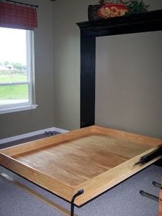 a wooden tray sitting on the floor in front of a window