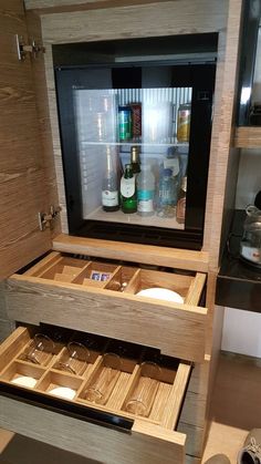 an open refrigerator filled with lots of bottles and glasses