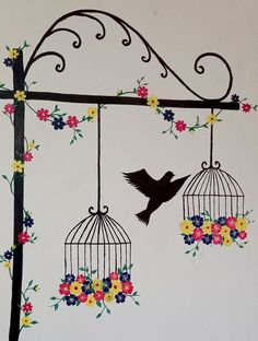 a bird is sitting on top of a cage with flowers and birds flying around it