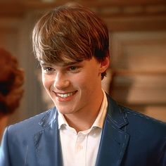 a young man in a blue suit smiling