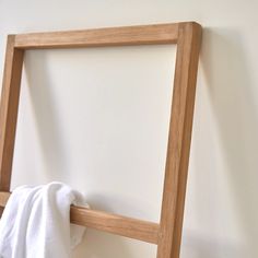 a towel is hanging on the wall next to a wooden frame with a folded white cloth