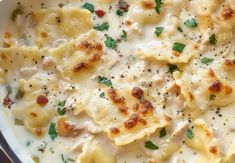 a white dish filled with ravioli and cheese