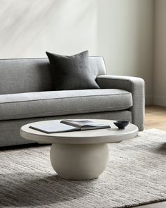 a living room with a gray couch and white coffee table