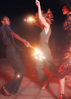 two women are dancing on the street at night