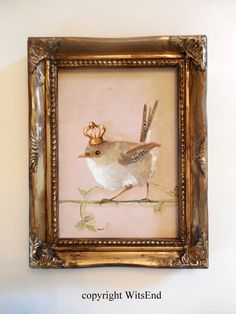 a painting of a bird with antlers on it's head hanging in a gold frame