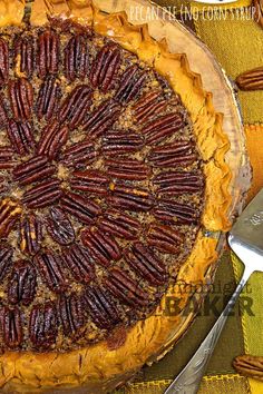 a pecan pie on a table next to a knife and fork