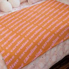 an orange and pink bed spread with white teddy bears