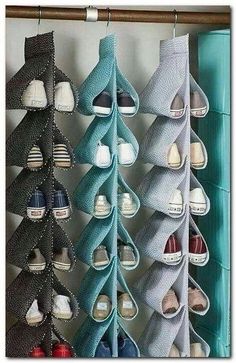 several pairs of shoes are hanging on a rack in front of a window with blue curtains