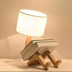 a lamp that is sitting on top of a wooden stand with a book in it