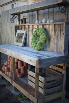 an old wooden table with pots and plants on it