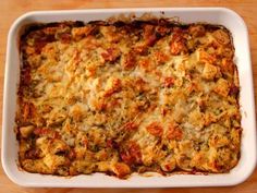 a casserole dish with meat and cheese in it sitting on a wooden table