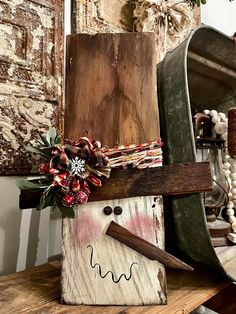 a snowman made out of wood sitting on top of a wooden table next to a mirror