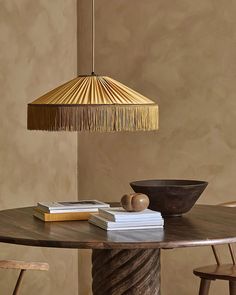 a wooden table topped with books and a light hanging from the ceiling over it's head