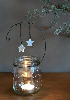 a glass jar with two stars hanging from it