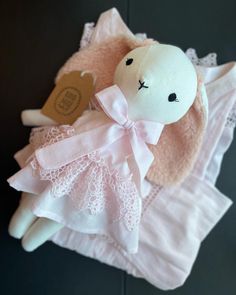 a white stuffed animal with a pink dress